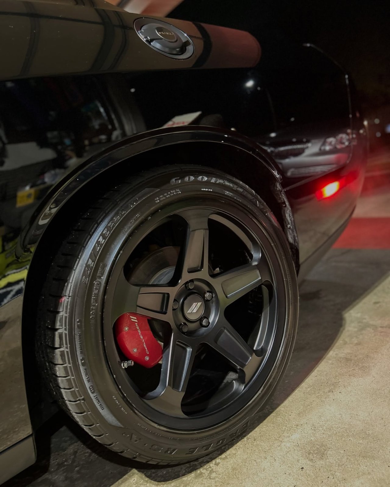 Brake calipers refinished in red behind the wheel