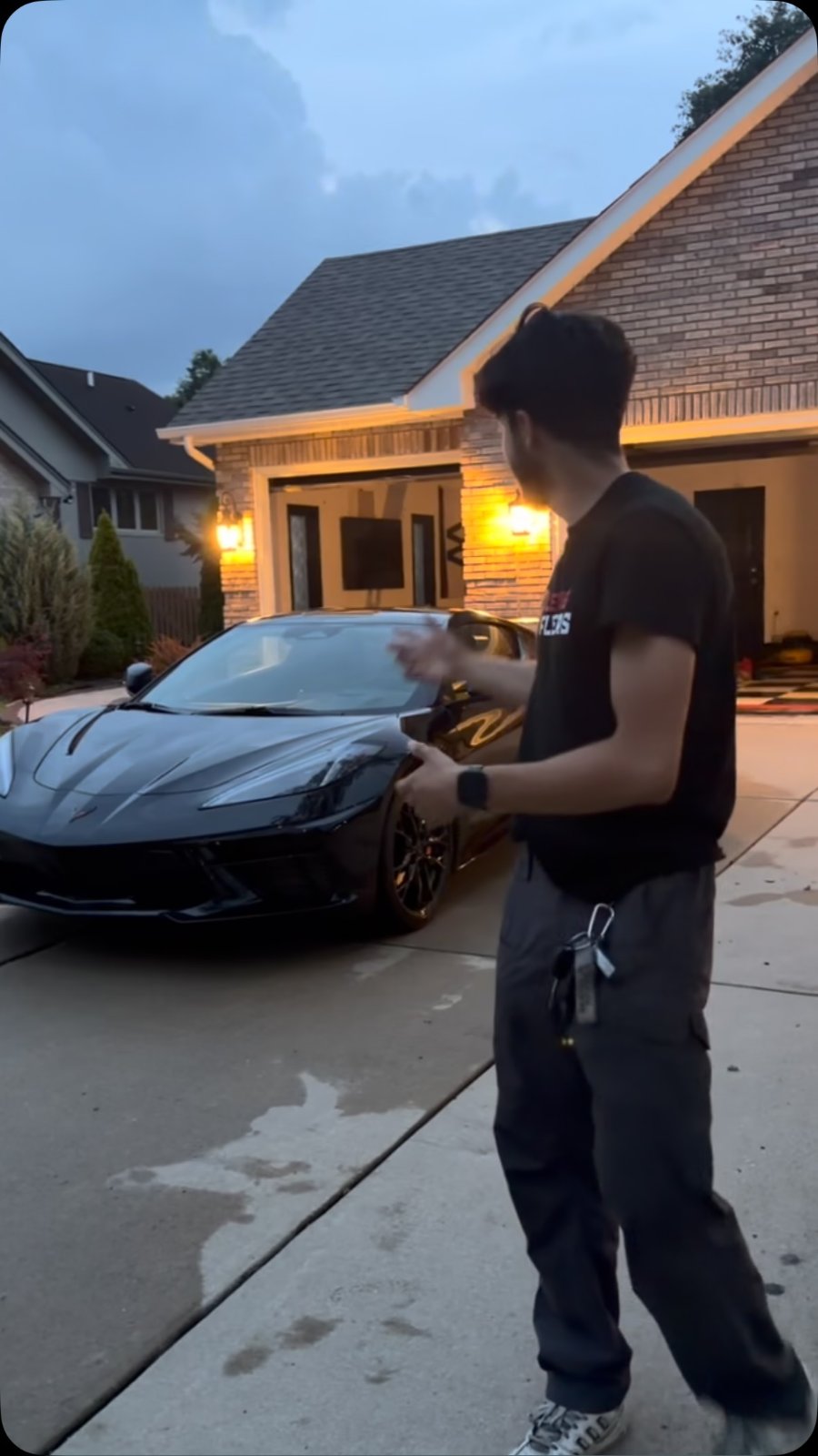 Zoom Aesthetics detailer with a freshly finished black Corvette at dusk